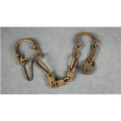 Slave trade- type leg irons with lock; heavy  brown patina, unknown age.  Est.:  $100-$300.