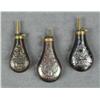 Image 1 : Lot of three reproduction brass embossed  powder flasks in overall very good condition.   Est.:  $75
