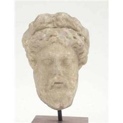 A Romanesque carved marble bust of a bearded...