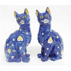 A pair of Galle style figures of a seated...