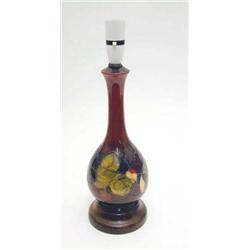 A Moorcroft bottle lamp with clematis on a...