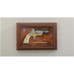 Miniature wood and glass cased copy of a  Southerner single shot derringer with  engraved brass fram