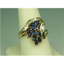 Dazzling 14 karat yellow gold ladies swirl  design ring set with 11 MQ shape blue  sapphires and cha