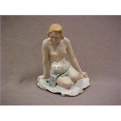 Porcelain figurine of a seated nude woman w