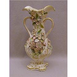 A TWIN HANDLED FLOWER ENCRUSTED VASE