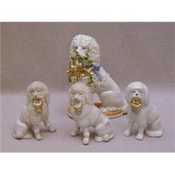 A SET OF THREE GLAZED BISQUE POODLES
