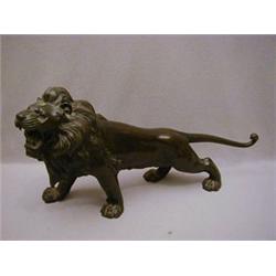 AN ORIENTAL BRONZED METAL FIGURE OF A LION