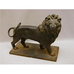 A CAST IRON DOORSTOP OF A LION PASSANT GARDANT