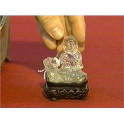 Small and old, Chinese clear rock crystal figure of a seated Immortal holding a peach, circa 1900, w