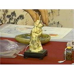 Well-carved and lightly polychromed, marine ivory (hippo tusk) okimono of a beauty with flower (spli