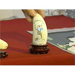 Scrimmed whale's tooth with lady liberty design, wood stand