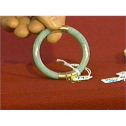Pale green jadeite bangle bracelet with yellow gold mounts