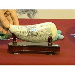 Very finely detailed, scrimmed whale's tooth with sailing ships in harbor design, wood stand