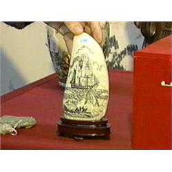 Finely scrimmed, large whale's tooth with design of whaling ship, dinghy and whale emerging from the