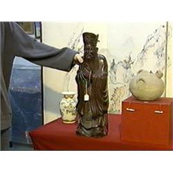 Well-detailed and carved, old and tall, Chinese hardwood figure of a standing bearded sage holding a