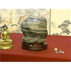 Chinese mountain-like scholar's rock with horizontal banding of gray and black coloration, wood stan