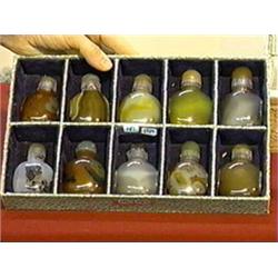 Group of ten, well-hollowed Chinese agate snuff bottles with matching tops, most with carved mask de