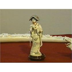 Very finely detailed carved ivory okimono of a woman with hat, biwa and pick; good polychrome scrimm