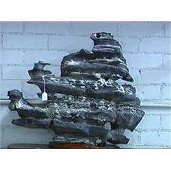 Massive Chinese gray and white layered stone scholar's rock of somewhat mountainous form, wood stand