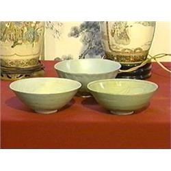 Three early Chinese celadon bowls: two Yueh-type with incised lotus designs (rim repair to one); tog