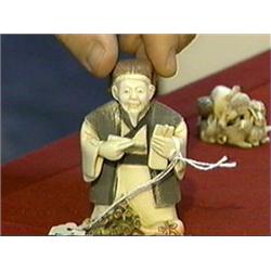 Small, carved and polychromed, ivory okimono of a man with double gourd vessel and flowering branch 