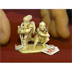 Finely carved and highly detailed, lightly polychromed ivory netsuke of two actors with swords, one 