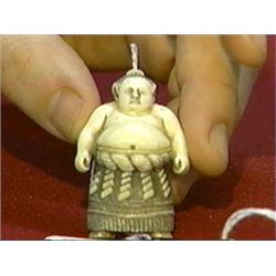 Very well-detailed, carved and stained, ivory netsuke of a sumo wrestler in traditional garb, signed