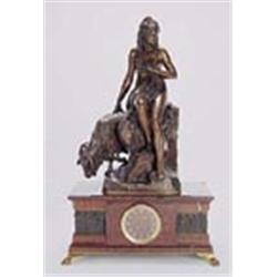A French red marble mantel clock surmounted with a statue; the eight day two-train movement striking