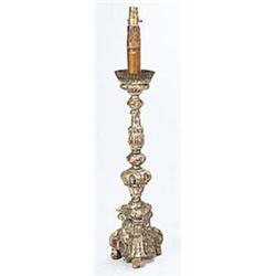 An 18th century Italian silvered wood altar type candlestick, with carved detail and triform base, n