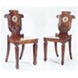 A pair of Regency mahogany hall chairs, in the manner of Tatham, each with a scroll carved shield sh