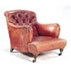 A Howard and Sons armchair, upholstered in red Morroco leather with a buttoned back, on mahogany tur