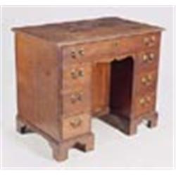 A George III oak kneehole desk, the rectangular top with moulded edge above seven drawers with later