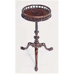 A George III mahogany kettle stand, the round top with a turned spindle gallery, on a spirally flute