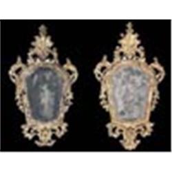 A pair of mid 18th century Italian giltwood wall mirrors of cartouche form, each with a shell crest,