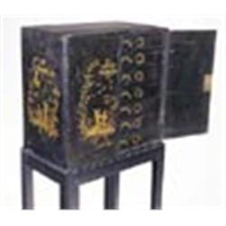 An early 19th century japanned cabinet on later stand, the cabinet painted with figures in oriental