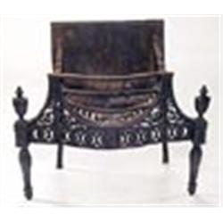 A cast iron serpentine fire grate in neoclassical style with scrolls and patera, urn finials and tap