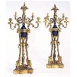 A pair of late 18th century French ormolu candelabra, each with a pomegranate finial and a basket of