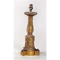 A French Empire ormolu candle stand stamped by Thomire, the reeded round drip pan above a stiff leaf