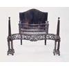 A serpentine steel fire grate with a scroll pierced apron, supported on columns, with obelisk finial