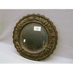 Oval bevelled edged mirror surrounded by pierced metal frame decorated with cherubs and griffins.