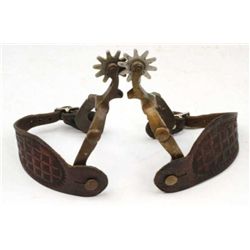 Unmarked brass drop shank spurs with aluminum rowel and unmarked leathers.