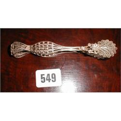 A pair of silver filigree sugar tongs...