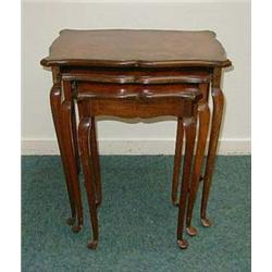 Nest of three walnut occasional tables on cab