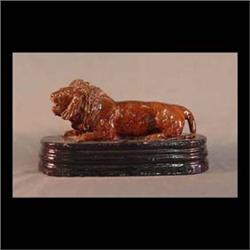 Sewer tile lion door stop. Full figure lion. Brown glaze on a black  glazed base. Note small surface