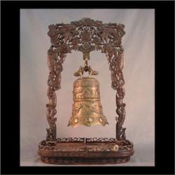 Ornate brass Oriental bell supported by an ornate pierce carved  wood frame. Bell 11"h x 7 1/2"d Fra