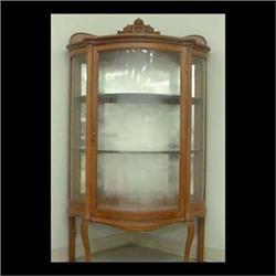 Curved glass oak china cabinet with mirrored back, carved gallery,  S-shaped side glass, bowed front