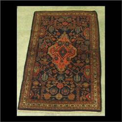 Hamadan Oriental rug. The center medallion has a rose colored  ground and rests on a dark blue field