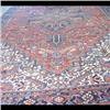 Image 1 : Heriz Oriental rug. The center medallion is in shades of red, blue,  and rust colors on a red ground