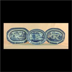 Three small Canton platters. Circa 1840. Two coffin-shaped and one  oval. Cloud rim, trees, bridge,