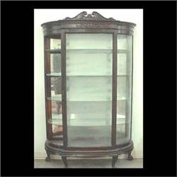 Curved glass oak china cabinet with carved and applied carved  decorations supported by claw and bal